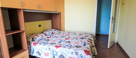 A bedroom with a bed, a wardrobe, and a door.