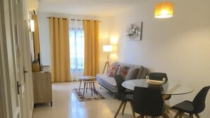 A living room with a sofa, a coffee table, and two chairs. There is a lamp on the wall and a window with curtains. - Wonderful apartment at Ronda IV Fuengirola (Fuengirola)