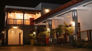 A two-story building with a covered entrance and multiple windows. - Royal Tulip Court (Accra)