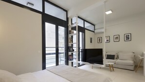 Une chambre moderne avec un grand lit, une télévision, un canapé et un balcon offrant une belle vue.