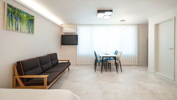 Una sala de estar moderna con sofá, mesa de comedor y sillas.