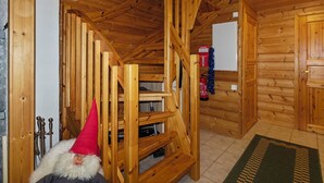 A wooden interior with a staircase, a fire extinguisher, and a door. - Kevätruska a by Interhome (Kittilä)