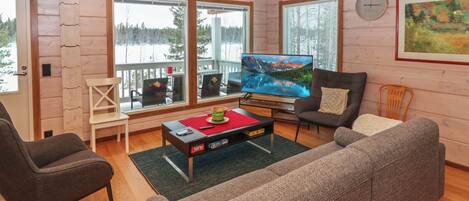 A cozy living room with a large flat-screen TV, a sofa, and a coffee table with a cake.