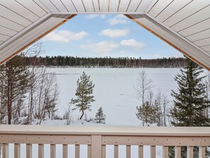 A wooden deck with a view of a frozen lake and forest. - Huvila tornionjoen rannalla by Interhome (Pello)