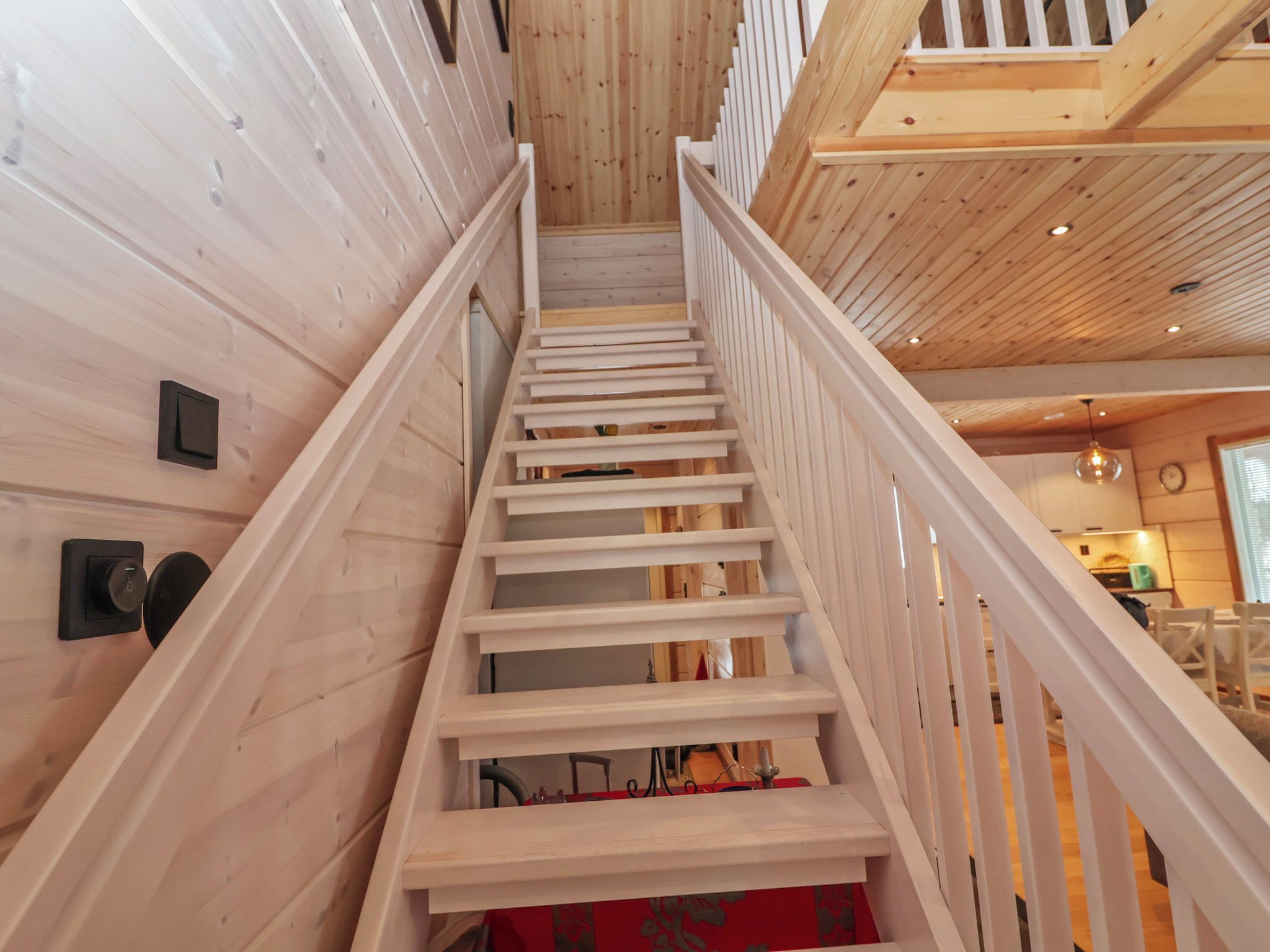 A wooden staircase with white railings inside a building.