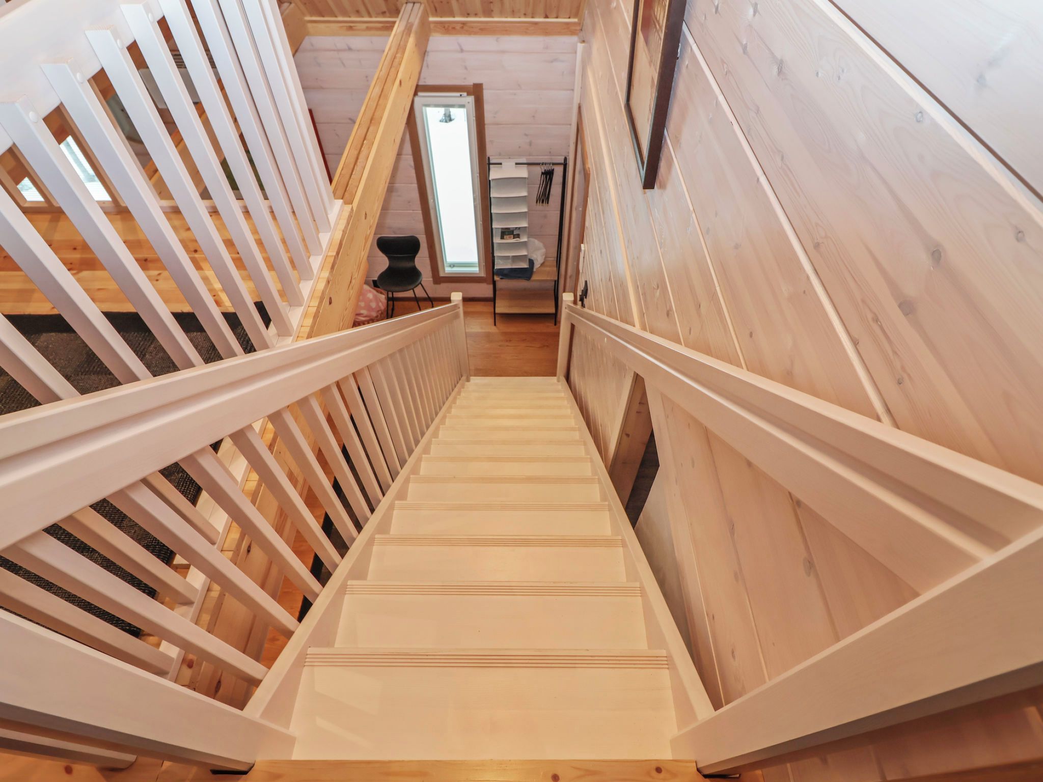 A wooden staircase with a handrail leading to an upper level.