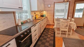 Een koelkast, een magnetron, een vaatwasser, kookgerei, borden en bestek