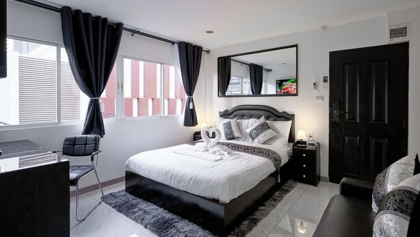 Una camera da letto moderna con un letto grande, una scrivania e una sedia.