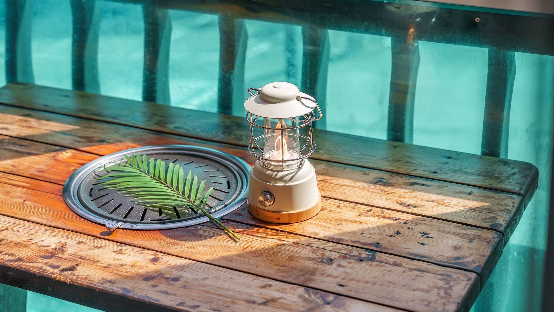 Une table en bois, un petit radiateur mobile, une feuille et un barbecue.
