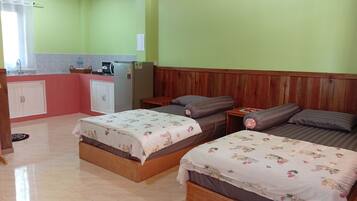 Ein Zimmer mit zwei Betten, einer Küchenzeile und einem hölzernen Kopfstück.