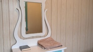 A vanity with a mirror, a book, and a folded towel. - Dinsmore Hotel (Dinsmore)