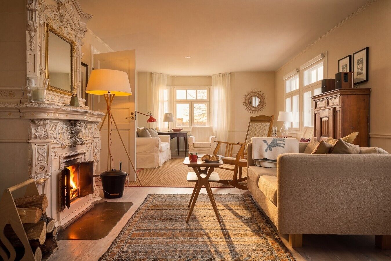 En hyggelig stue med pejs, sofa, sofabord og spisebord.