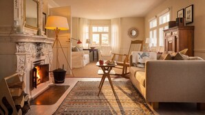 Una sala de estar acogedora con chimenea, un sofá, una mesa de centro y una mesa de comedor.
