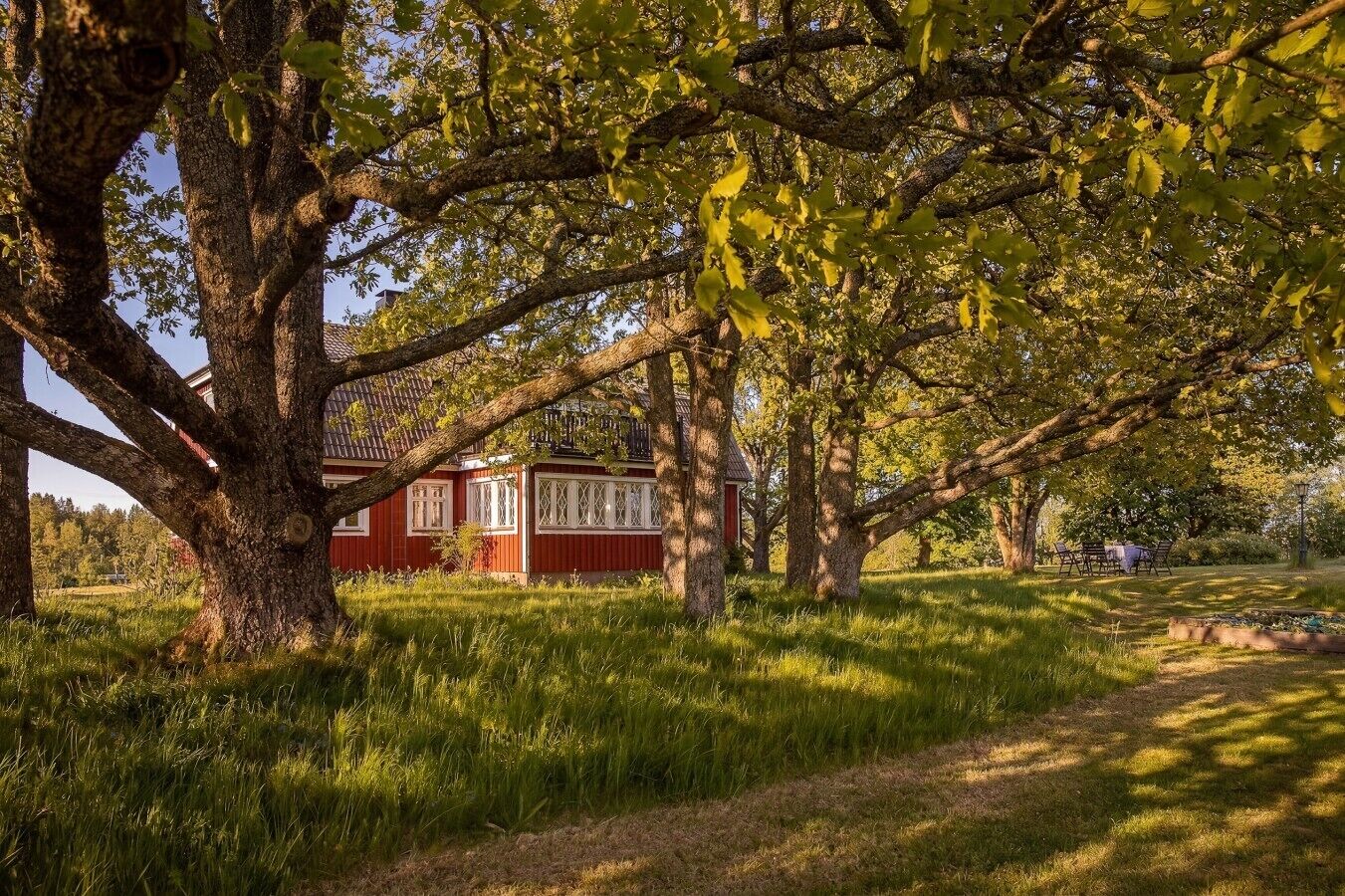 Een rood gebouw met witte details, omringd door bomen en gras.