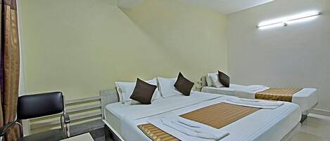 A hotel room with two beds, a desk, and a chair.