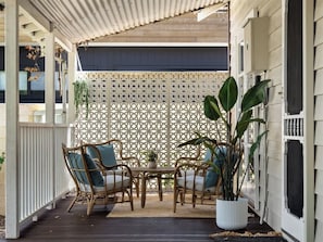A covered patio with wicker furniture and a lattice screen.