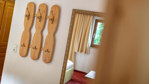Une pièce avec un décor mural en bois, un miroir doté d’un cadre orné et une fenêtre avec des rideaux.