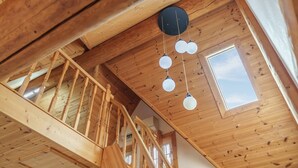 A wooden interior with a staircase, a skylight, and hanging light fixtures. - Daecheon Ocean Forest Pension (Boryeong)