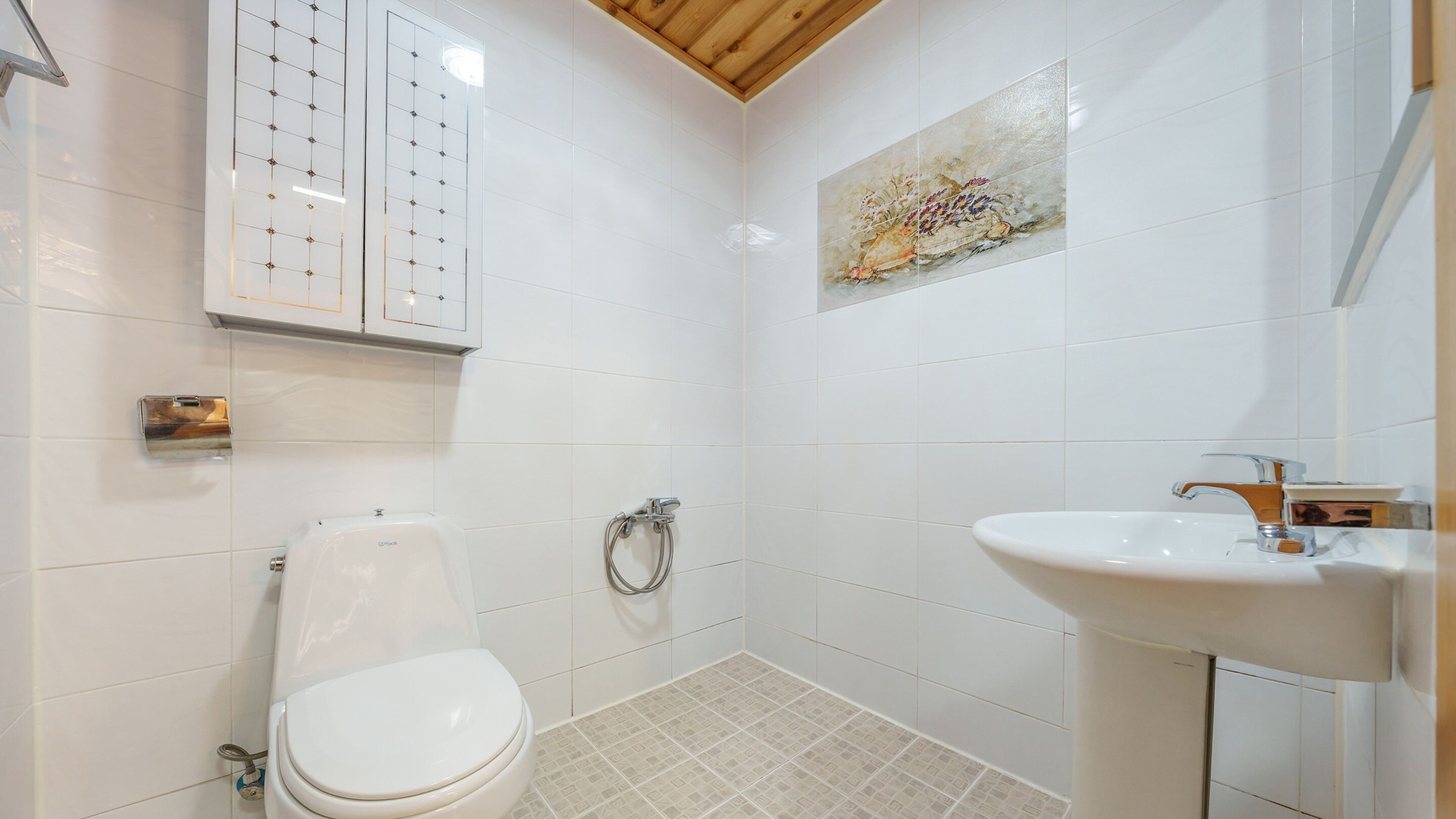 Une salle de bain avec des toilettes, un lavabo et une douche.