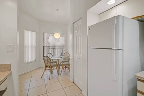 Enjoy meals in this kitchen with a refrigerator, dining table, and four chairs.