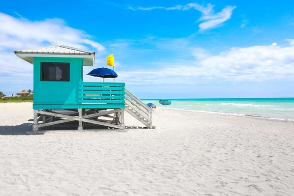 Enjoy the view from our lifeguard tower, featuring a flag and umbrella.