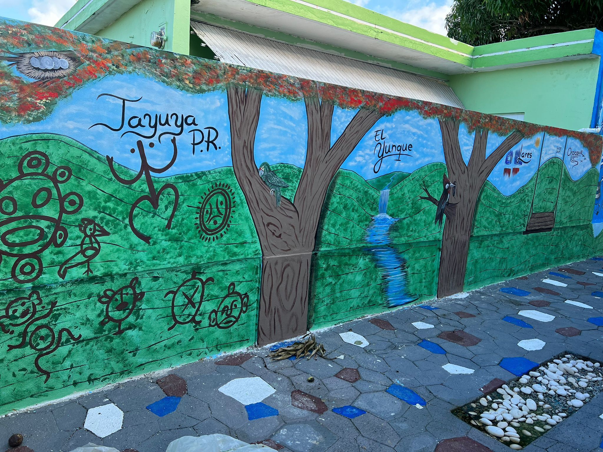 A mural with trees, a bird, and text on a wall.