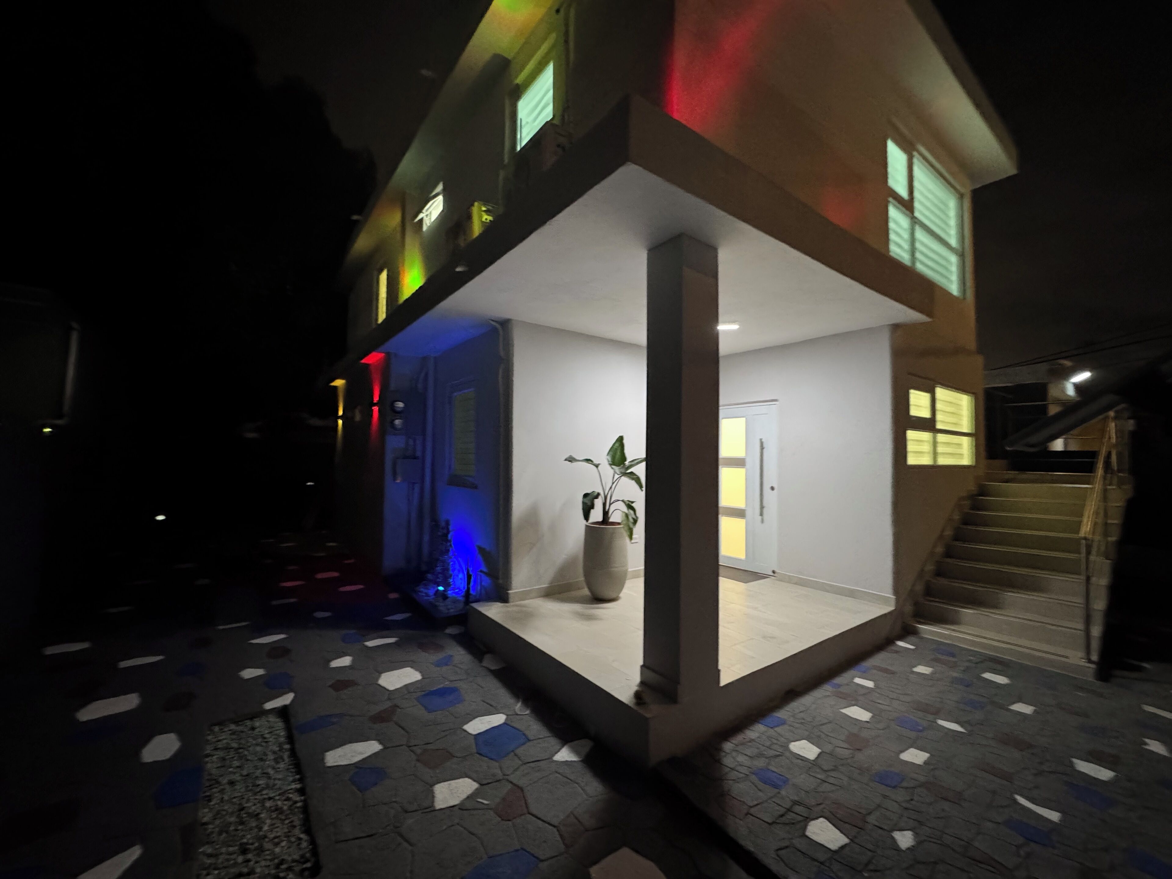 Un edificio moderno con un patio central, una escalera y una planta en maceta.