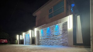 A building with a stone facade and illuminated blue signage. - Villa Tropicana  (Carolina)