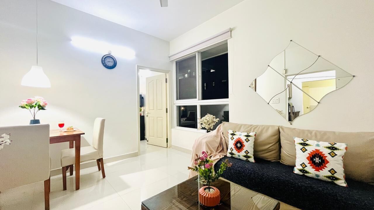 A modern living room with a sofa, coffee table, and dining area.