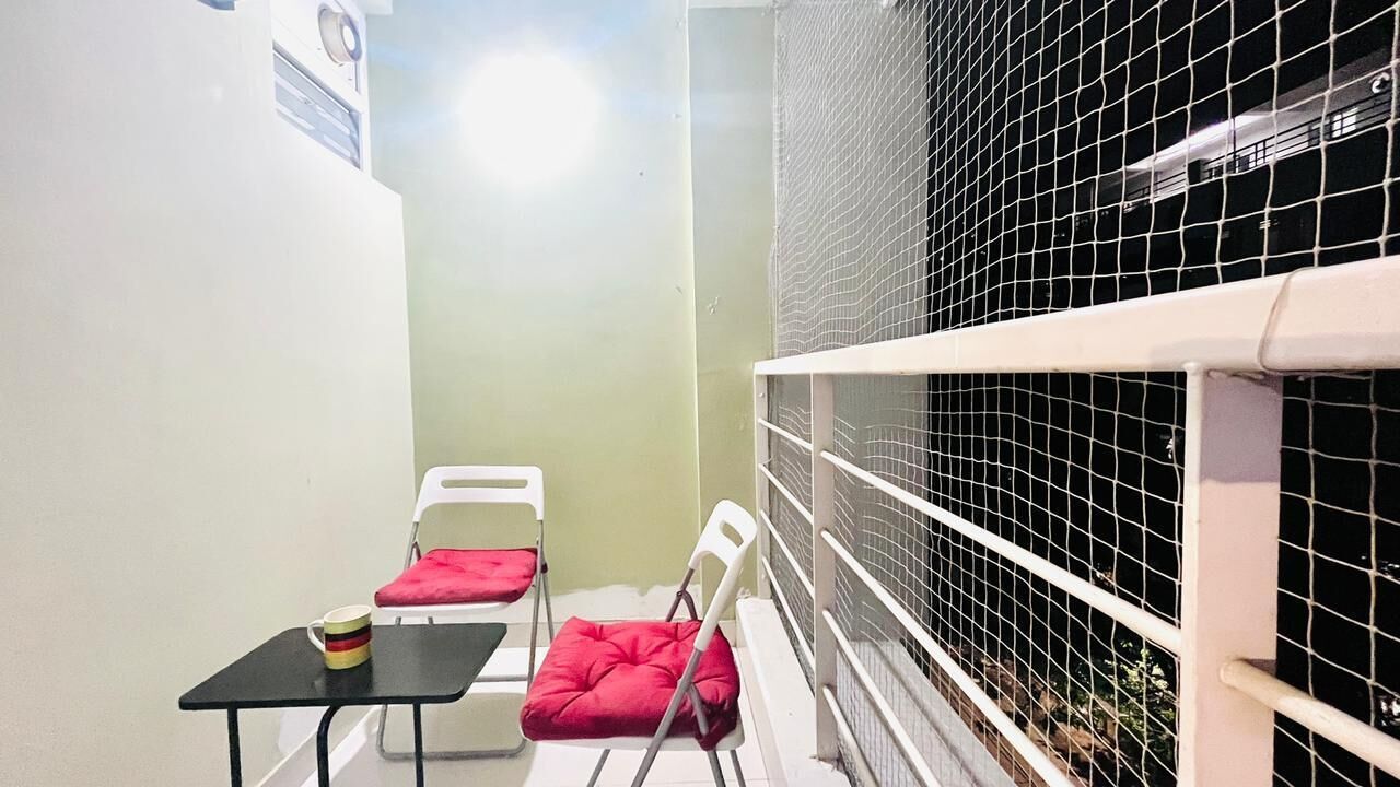A room with a bed, a small table, two chairs, and a window.