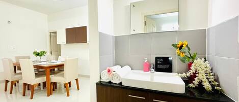 Un baño moderno con lavamanos, espejo y artículos de aseo.