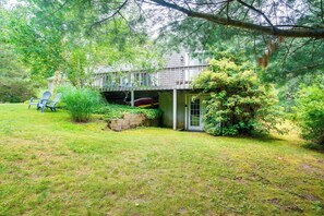 Una casa con un portico coperto, un garage e un piccolo giardino con sedie e piante.