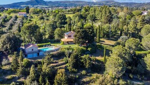 A villa with a swimming pool, surrounded by lush greenery and hills. - Vacation home Lilia by Interhome (Riparbella)