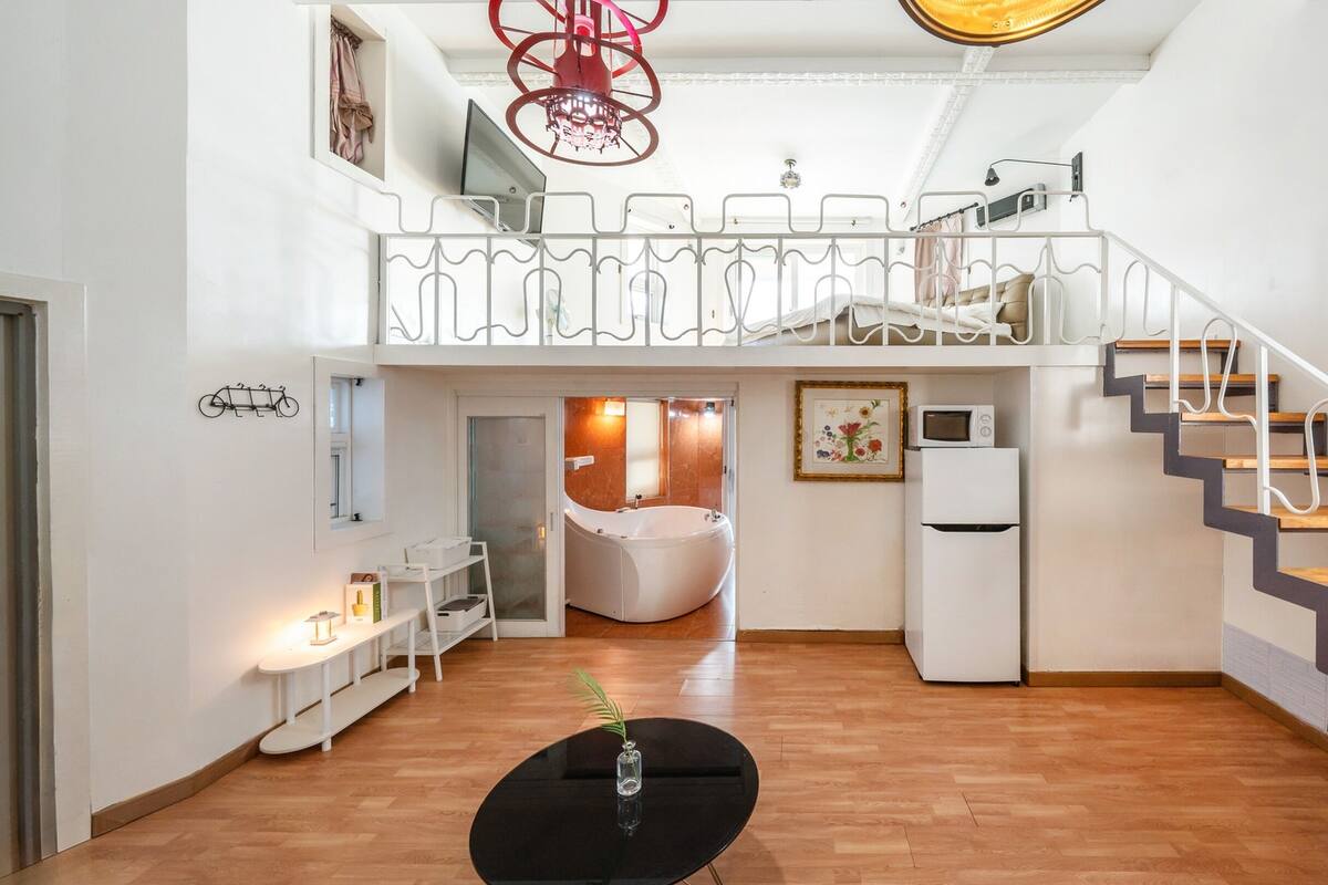 Ein geräumiger Wohnbereich mit Treppe, einer Küche und einem Badezimmer.