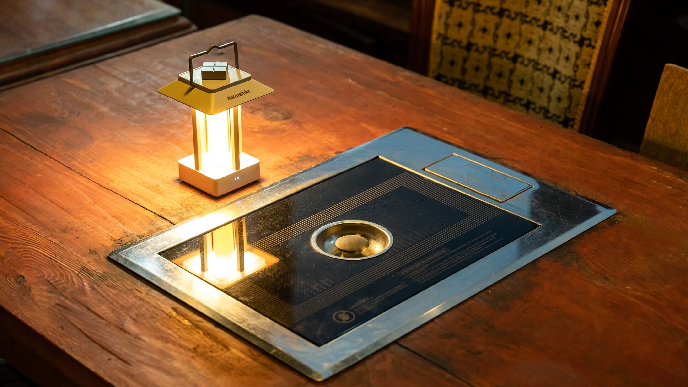 Une table sur laquelle se trouvent une cuisinière électrique noire et argentée et un radiateur portatif jaune.