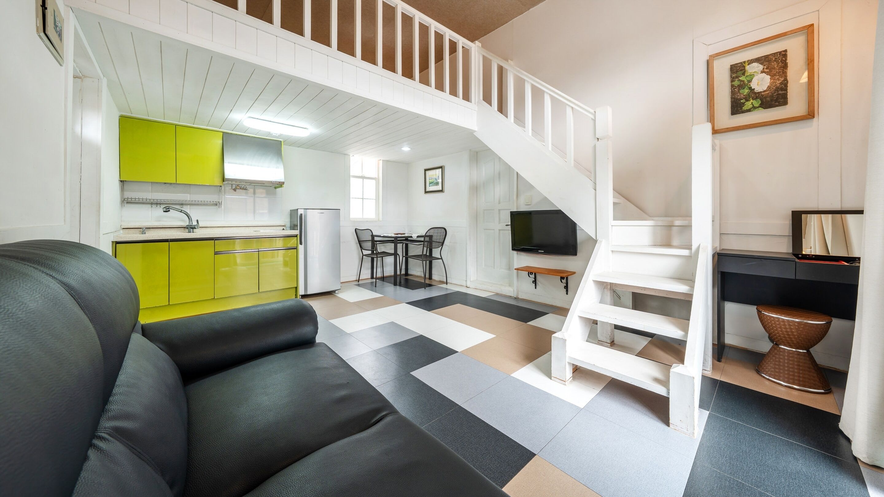 Un apartamento moderno con sala de estar, cocina y una escalera.
