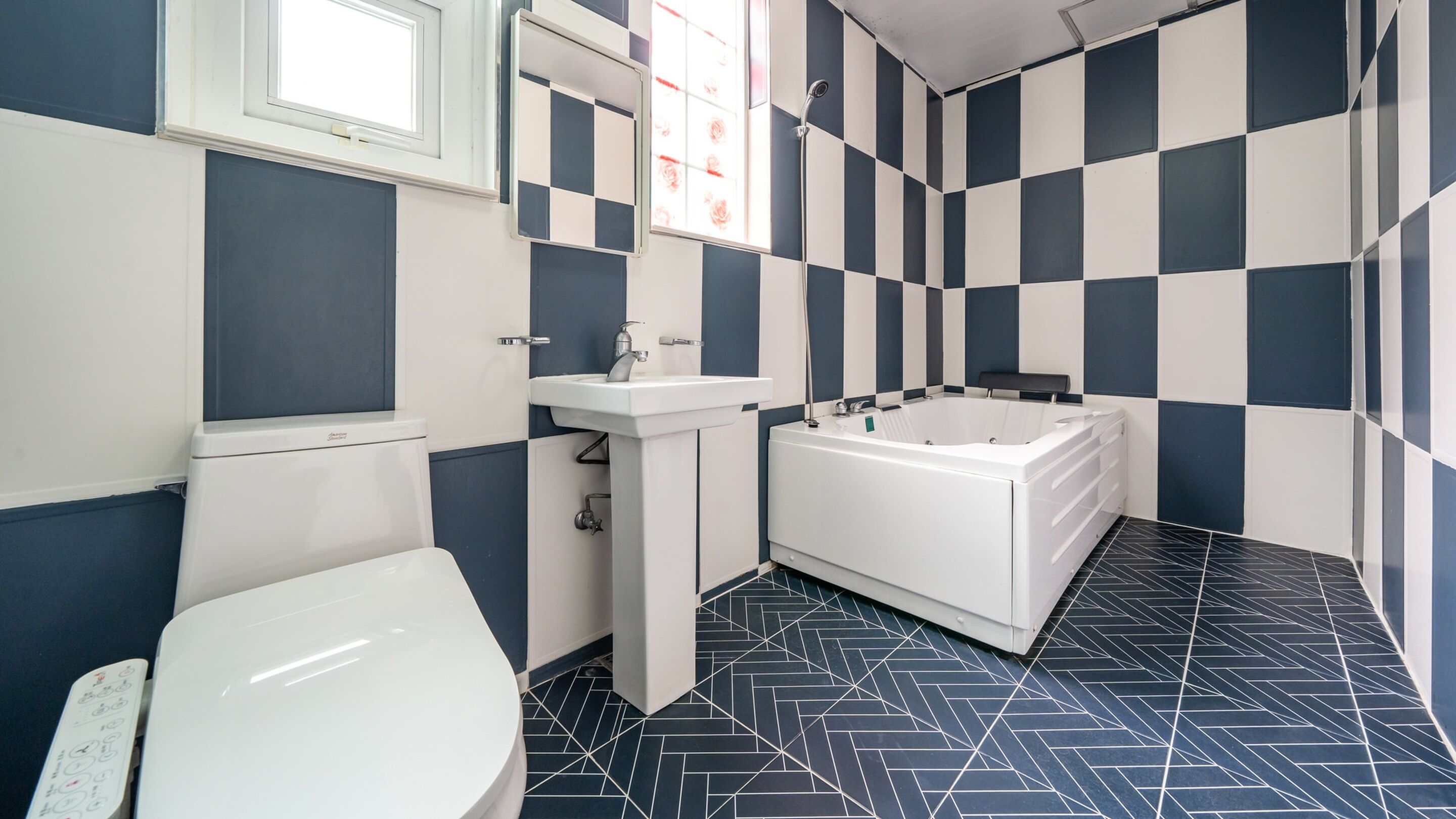 A bathroom with a toilet, sink, and bathtub.