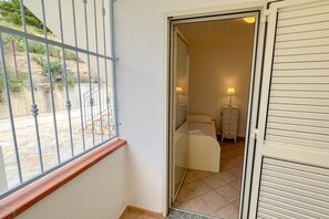 Una habitación con cama, cómoda y lámpara.