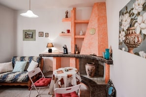 Ein gemĂŒtliches Wohnzimmer mit einer Couch, Sesseln, einem kleinen Tisch und einem dekorativen Regal.