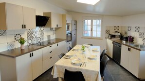Et moderne køkken med et spisebord til fire personer, indbygget ovn og et vindue med udsigt.
