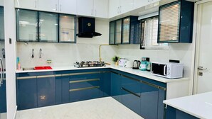 Una cocina moderna con armarios blancos, una estufa a gas, un microondas y un lavamanos.