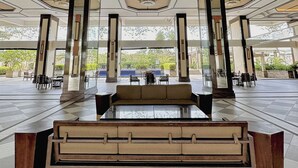 A spacious lobby with a central seating area, large pillars, and a geometric ceiling design. - 1BR Gem in MNL w/Pool, Fast WiFi, Netflix Near Luneta US Embassy & Intramuros (Manila)