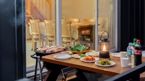 A table set for a meal with various dishes, a portable grill, and a lantern. - Yangyang Sunrise and Sunset Private Pens (Yangyang)