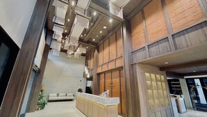 A spacious lobby with a reception desk, a staircase, and a seating area. - Sareeviengping Hotel Chiangmai  (Mae Rim)