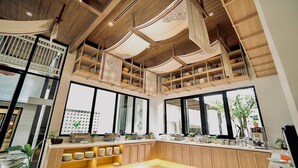 A spacious kitchen with high ceilings, wooden beams, and large windows. - Sareeviengping Hotel Chiangmai  (Mae Rim)