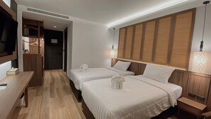 A hotel room with two beds, a desk, and a TV. - Sareeviengping Hotel Chiangmai  (Mae Rim)