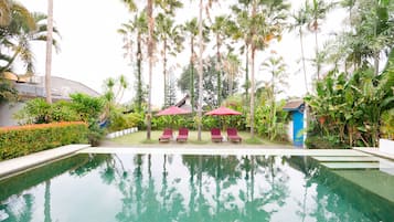 Una piscina al aire libre, tumbonas