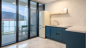 A modern kitchen with a built-in refrigerator, a sink, and blue cabinets. - Gyeongju Purspet Dog Pension (Gyeongju)