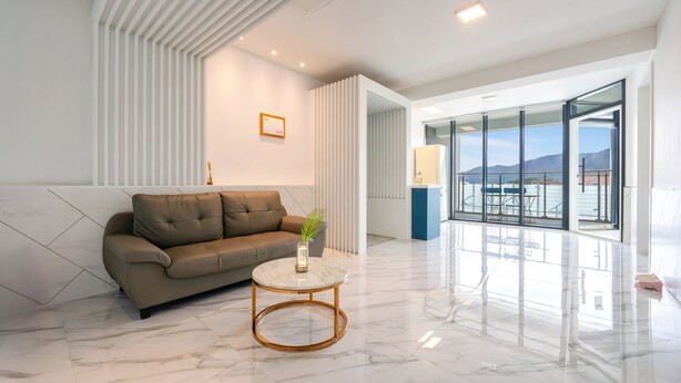 A modern living room with a sofa, a round coffee table, and a large window offering a view of the outdoors. - Gyeongju Purspet Dog Pension (Gyeongju)