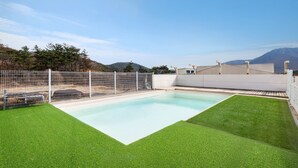 A rectangular pool with a white fence and artificial grass surrounding it. - Gyeongju Purspet Dog Pension (Gyeongju)